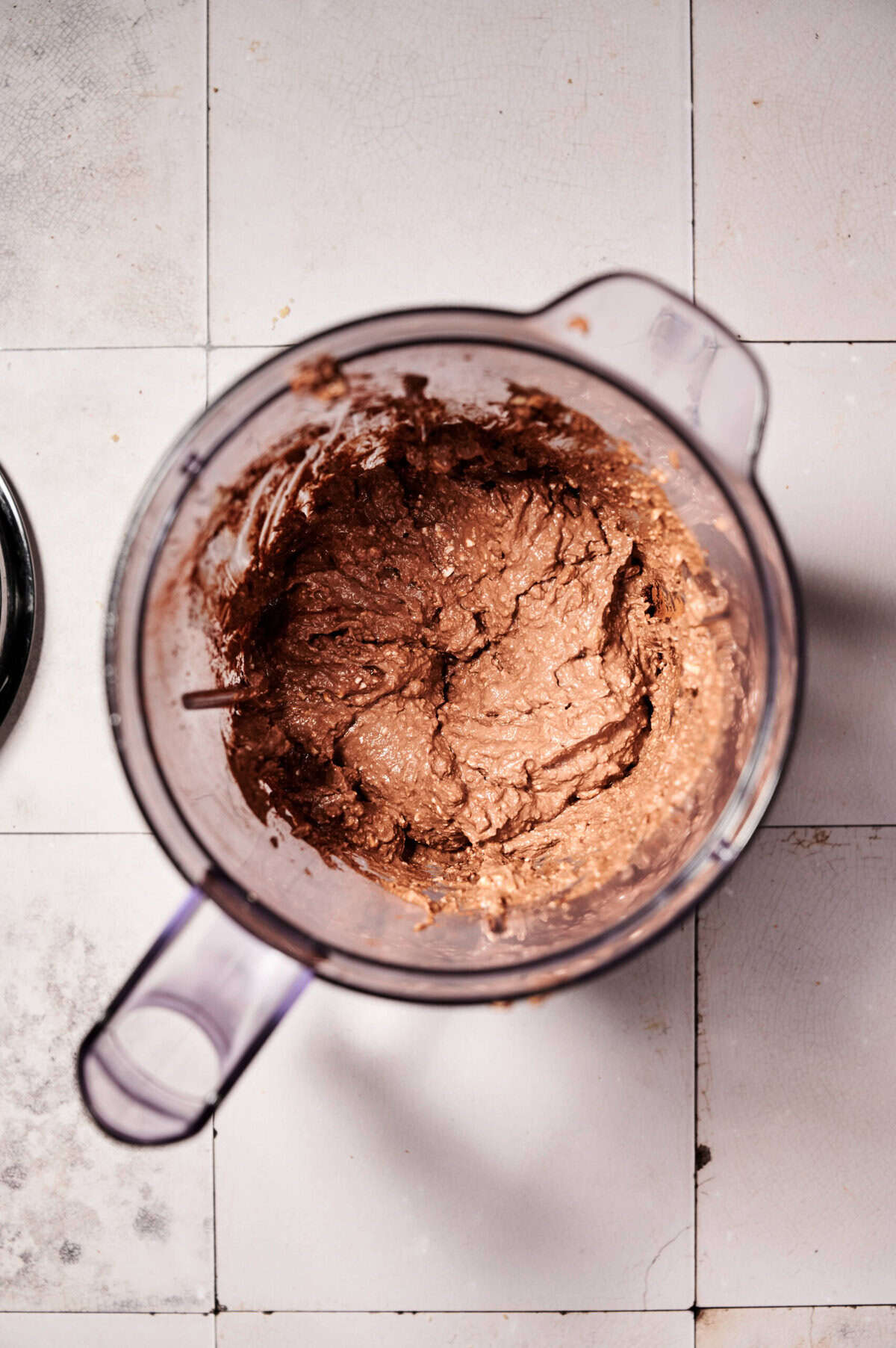 High protein chocolate mousse ingredients in a blender: cottage cheese, cocoa powder, and sweetener all creamed together/ blended for a healthy dessert.