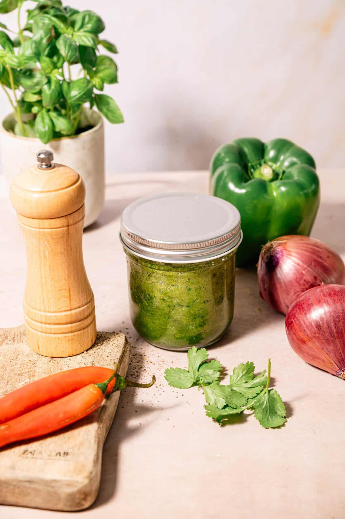 Jar of 5?minute homemade sofrito made with green bell peppers, red onions, garlic and spices on a light kitchen counter, ready to use as a Puerto Rican cooking base.