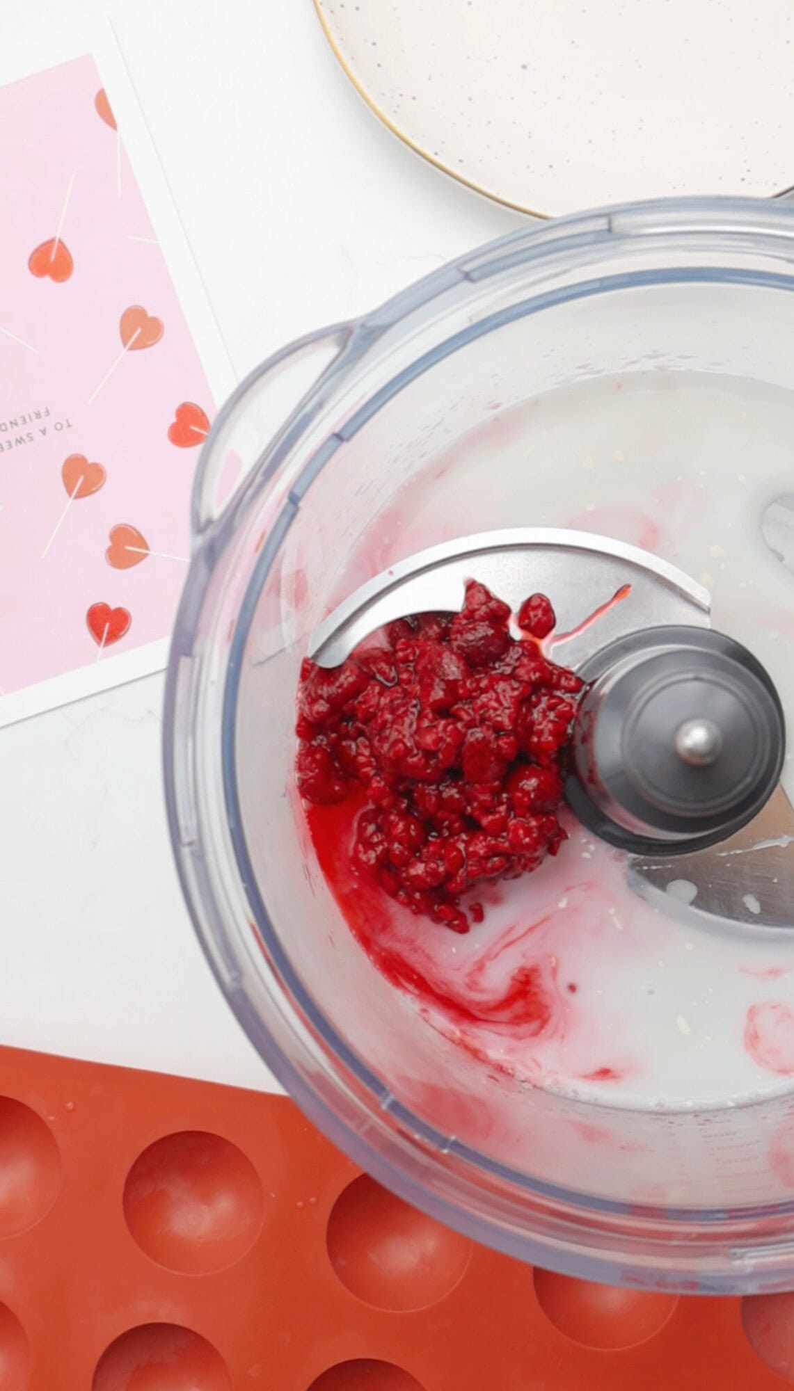 Frozen raspberries and almond milk in a food processor for raspberry truffle filling