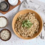 Bowl of fluffy bone broth rice and quinoa topped with fresh cilantro, a high protein rice side dish made with chicken bone broth.