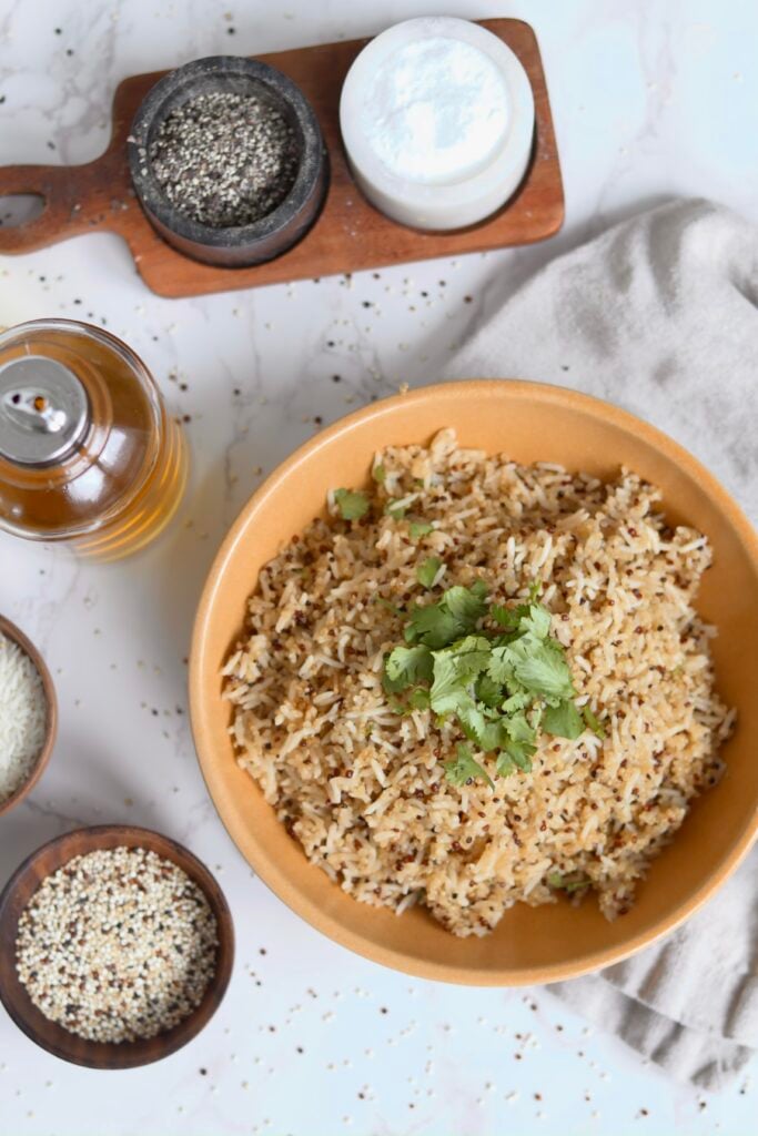 Overhead view of high protein bone broth rice and quinoa garnished with fresh cilantro in a tan bowl.