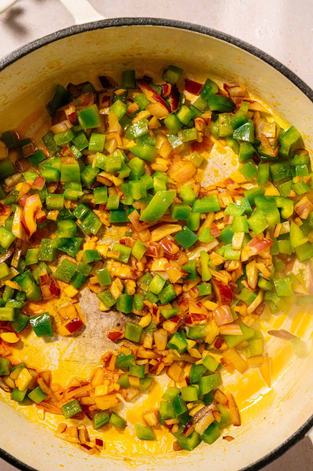 Onions, garlic, and green bell pepper sautéing in achiote oil to build flavor for seco de pollo ecuatoriano chicken stew.