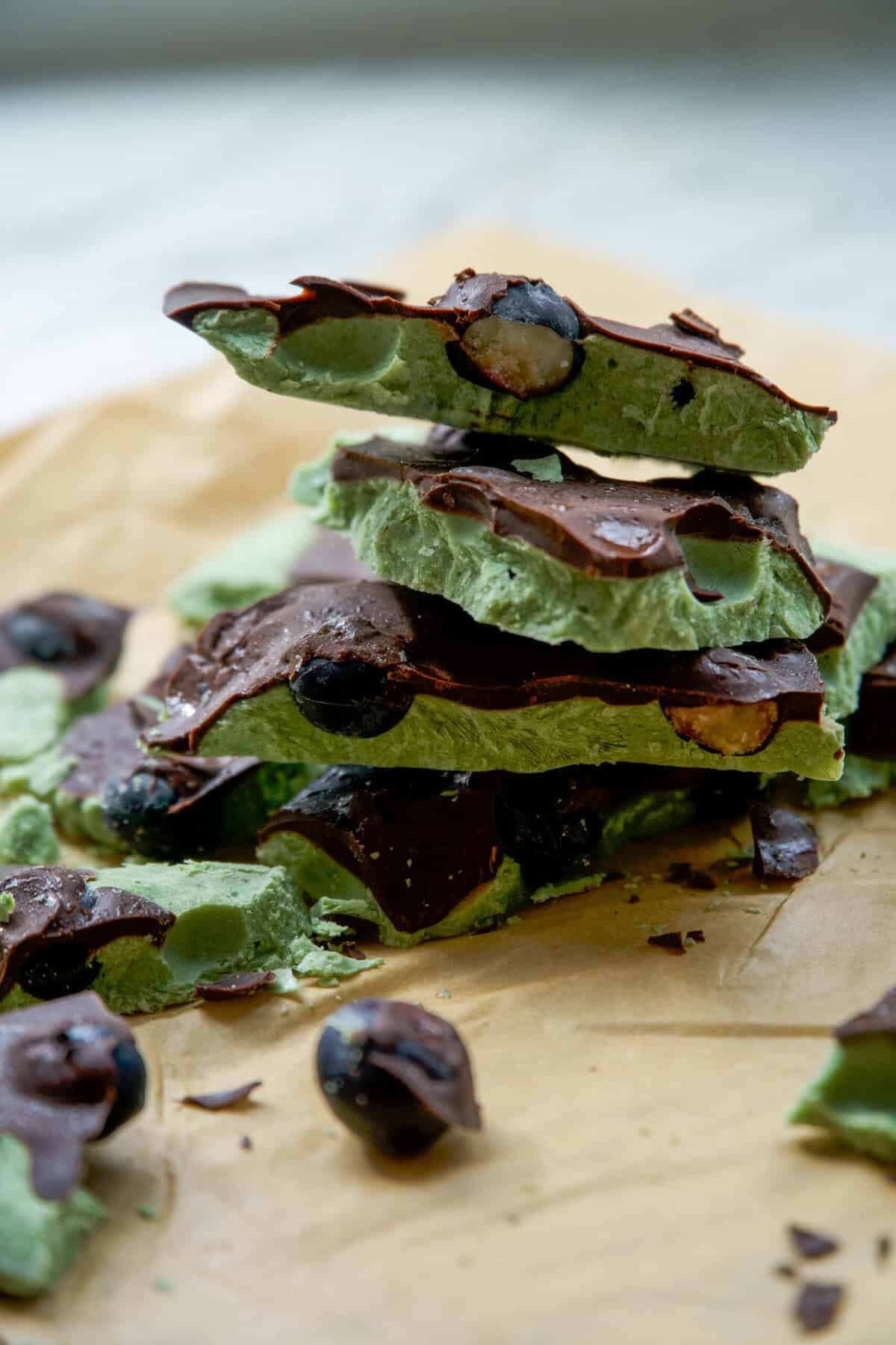 Greek yogurt blueberry bark with dark chocolate drizzle stacked on parchment paper
