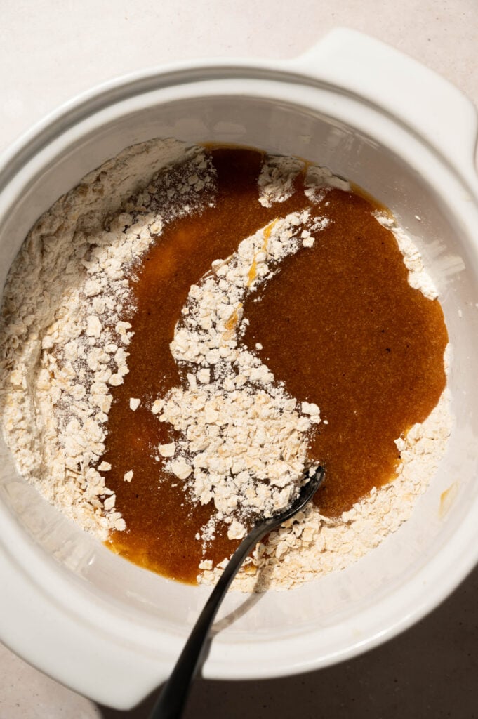 Folding the brown butter mixture into the oat and flour mixture