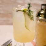 Easy pear cocktail topped with crushed ice and garnished with a pear slice and thyme sprig