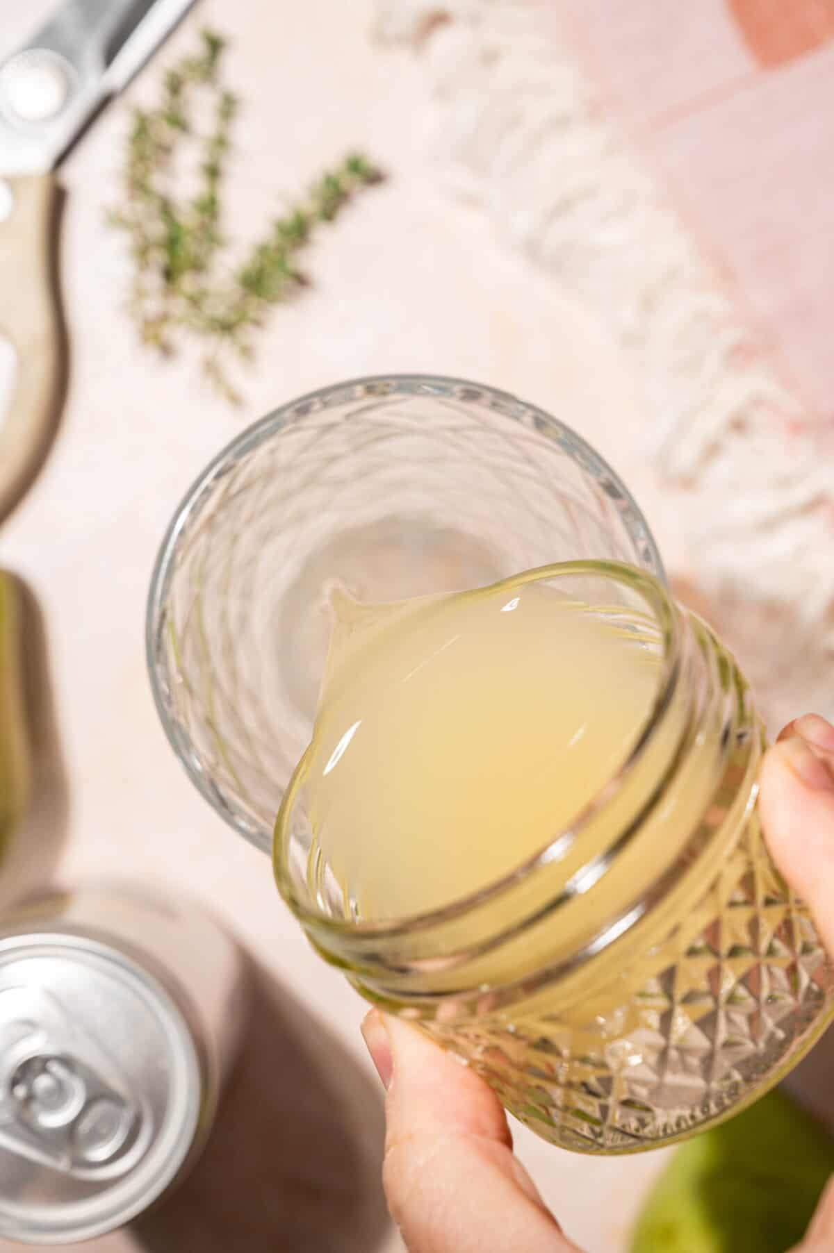 Pouring pear juice into a cocktail shaker for an easy pear cocktail