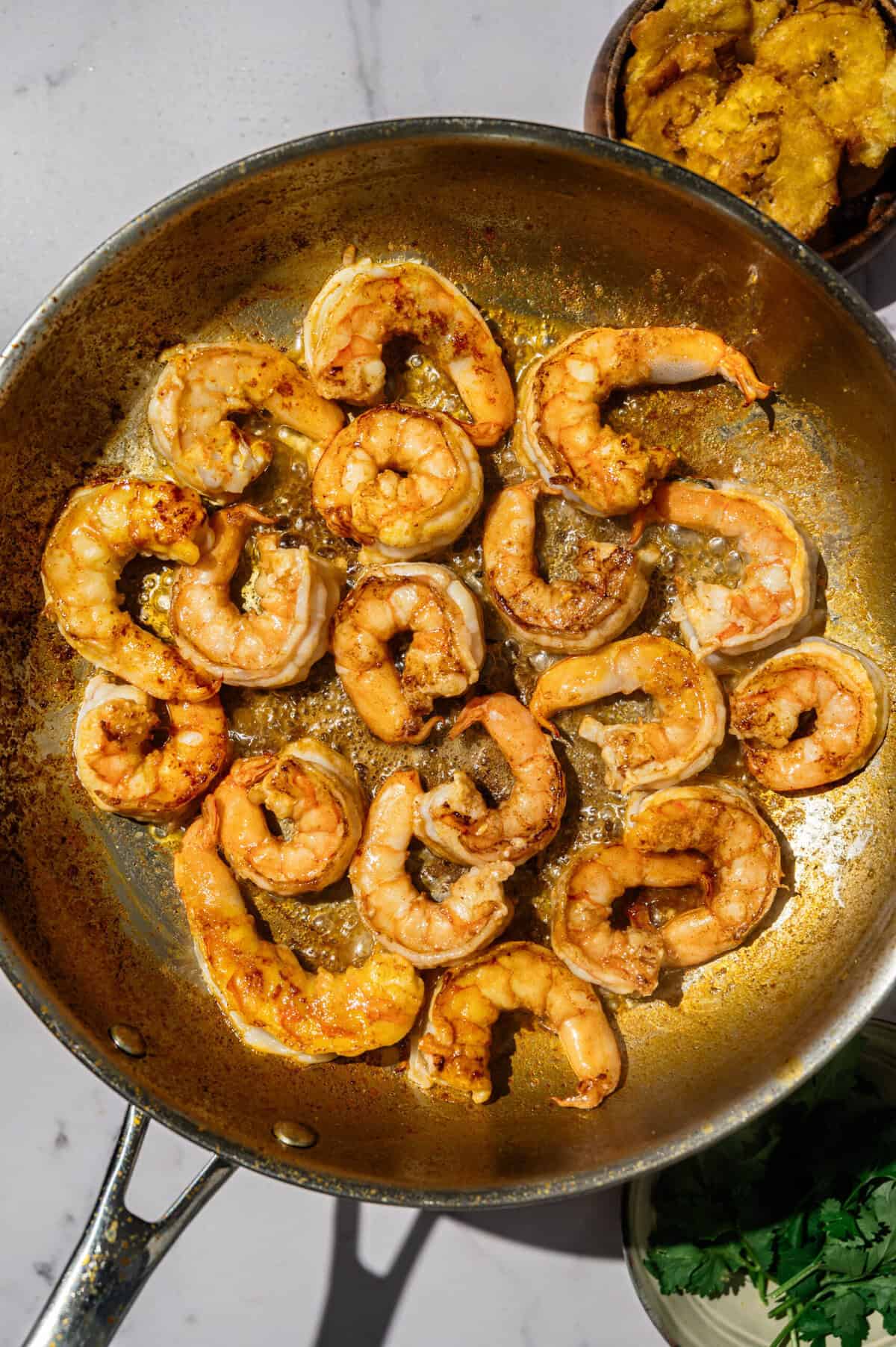 Shrimp searing in achiote oil until golden for Ecuadorian shrimp in coconut sauce