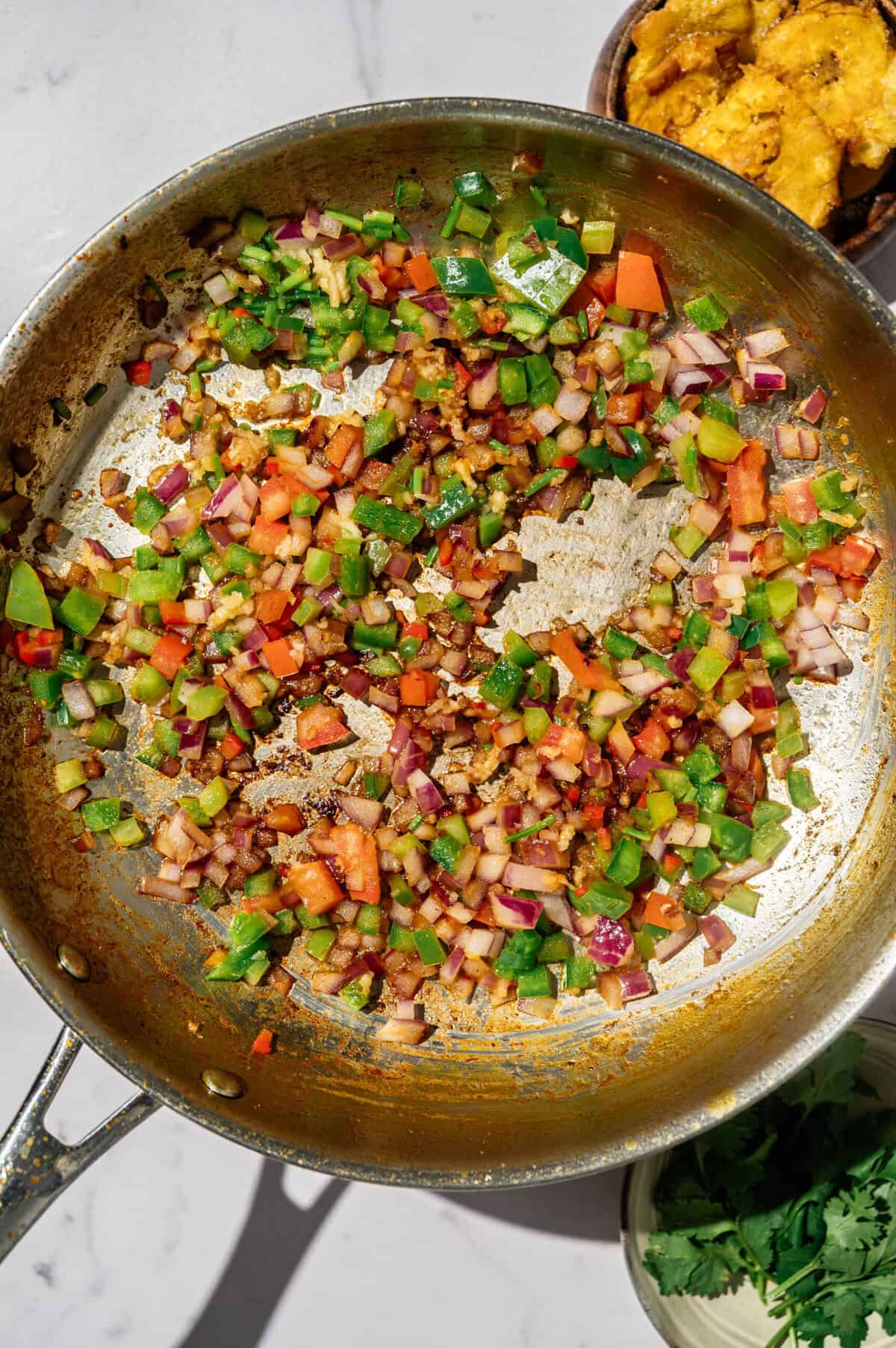 Refrito of onion, bell peppers, and garlic sautéing in the same skillet