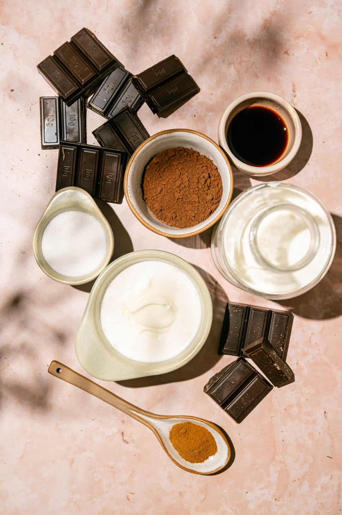Milk, heavy cream, chocolate, cocoa powder, sugar, cinnamon, and vanilla in a saucepan for an easy hot chocolate recipe.